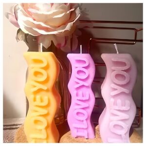velas de color amarillo y rosado con la frase I love you
